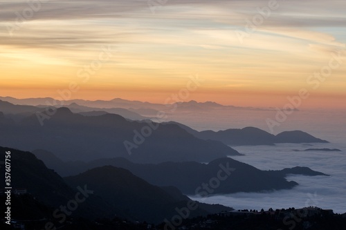landscape view of sunrise over the mountains with fog & clouds © Himalayan Gypsy