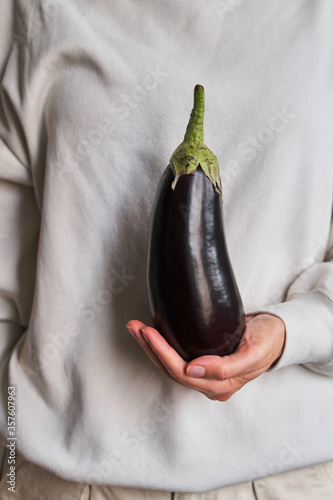 Fresh ripe eggplant in woman hands. Raw big purple aubergine. Healthy food, organic vegetables. Violet squash close-up. Natural vitamins, raw ingredient for eating. Handpicked bio eggplant