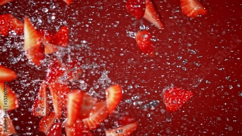 Super Slow Motion Shot of Fresh Strawberries and Water Side Collision on Red Background at 1000fps. photo