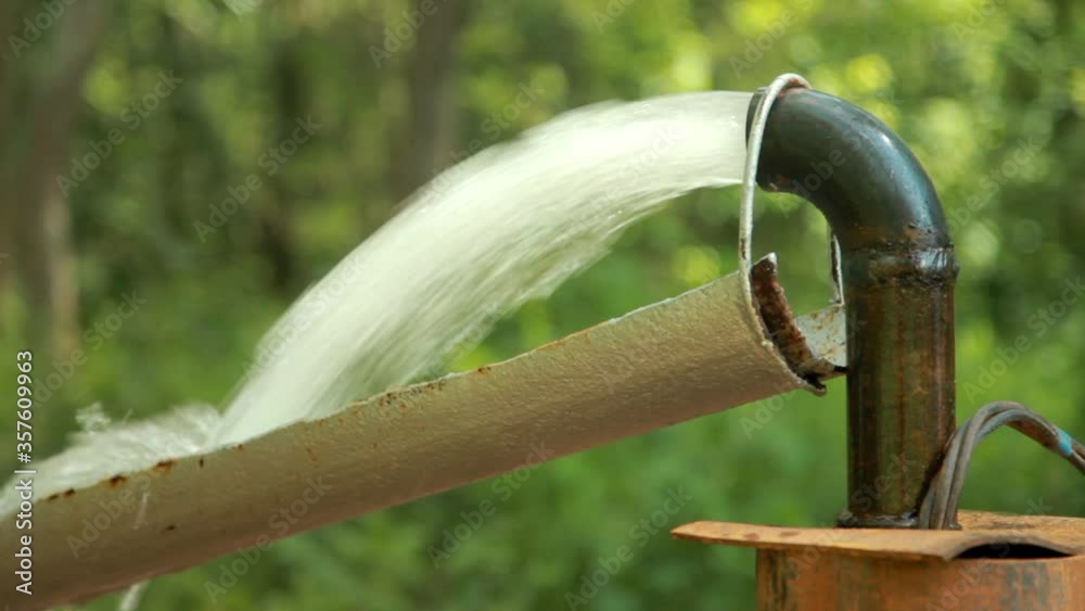 Water Pump.Powerful Water Flowing from a Pipe Pump.Water well drilling.Close-up. Water Pump.Powerful Water Flowing from a Pipe Pump.Water well drilling.Close-up.