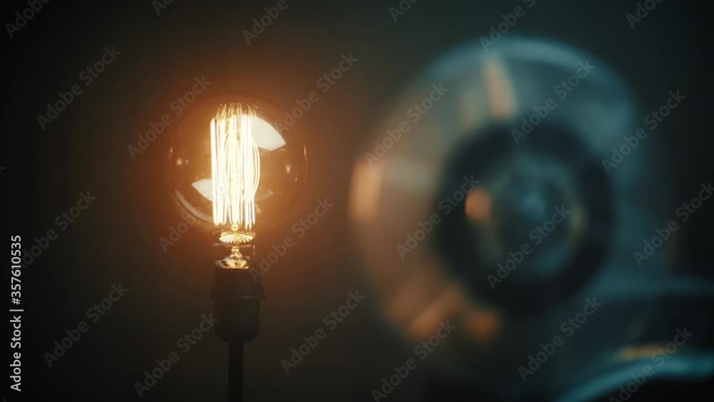 Film reel playing beside a light bulb Film reel playing beside a light bulb
