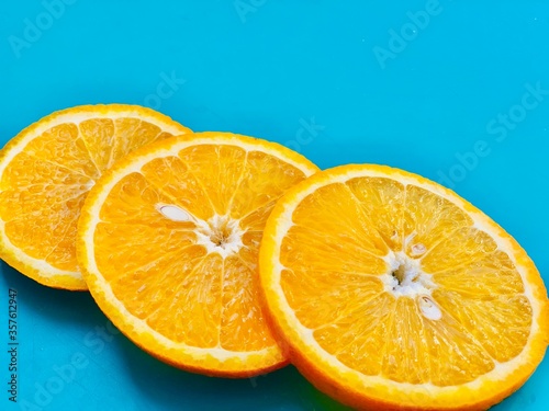 Fresh orange slice on blue background closeup. Flat lay  copyspace  top view.