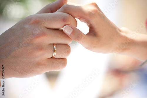 bride and groom holding hands with rings © Anna