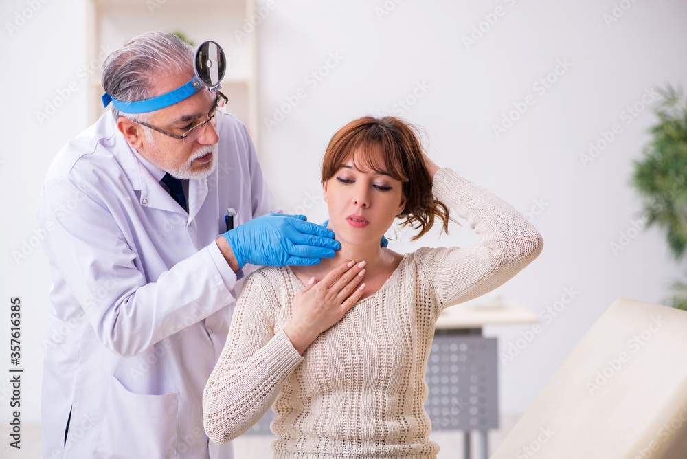 Young woman visiting old male doctor otorhinolaryngologist Young woman visiting old male doctor otorhinolaryngologist