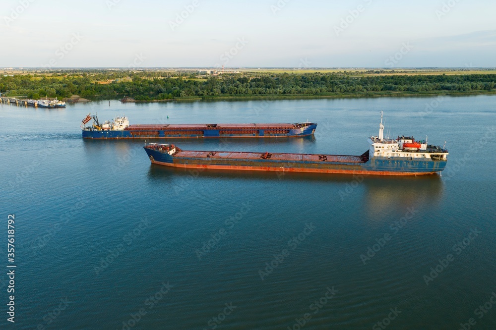 Commercial ship crossing the river. Aerial view. 