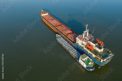 Commercial ship crossing the river. Aerial view. 