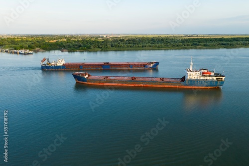 Commercial ship crossing the river. Aerial view. 