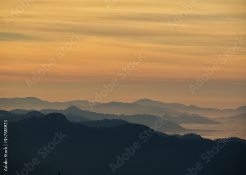 landscape view of sunrise over the mountains with fog & clouds © Himalayan Gypsy
