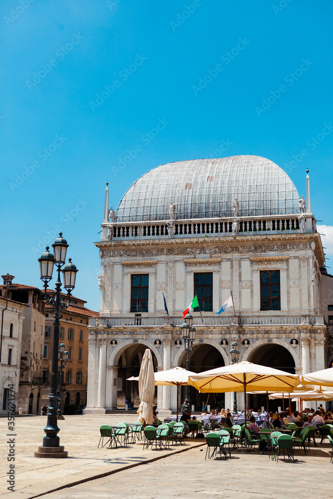 Naklejka premium Comune di Brescia - City or town hall of Brescia, Lombardy, Italy. The main Italian landmark with a round roof, white walls, windows, sculptures, flags of European Union. Architecture. Heritage.