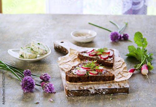 Open sandwiches on triangular rye bread with herbal butter and chopped fresh radish
