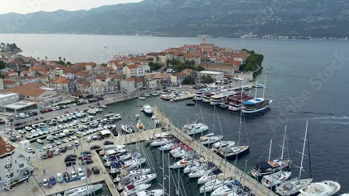 Aerial view of marina or port full of sailboats, yachts and boats in mediterranean city. Korcula Island in Croatia. View of hundreds sailboats during sunset in port, golden hour. photo