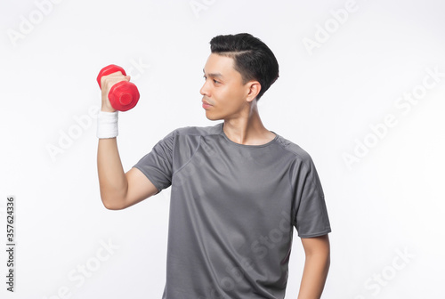 Young handsome asian man in sport outfits exercising with dumbbell isolated on white background. photo