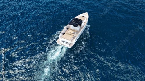 Aerial drone top down photo of small power boat with wooden deck cruising in deep blue Mediterranean sea © aerial-drone