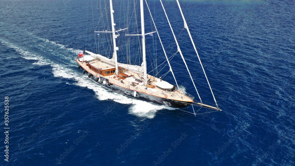 Fototapeta premium Aerial drone photo of beautiful sail boat with wooden deck sailing the Aegean deep blue sea, Greece