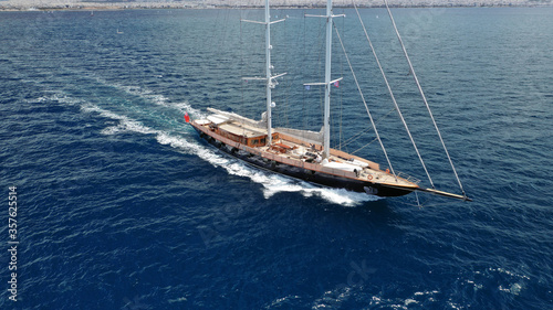 Aerial drone photo of beautiful sail boat with wooden deck sailing the Aegean deep blue sea, Greece