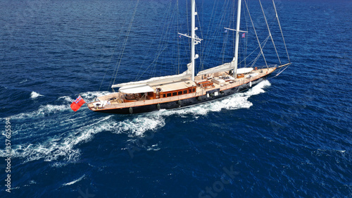 Aerial drone photo of beautiful sail boat with wooden deck sailing the Aegean deep blue sea, Greece