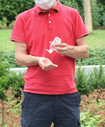 Male using sanitizer to desinfect his hands to protect himself from getting the corona disease