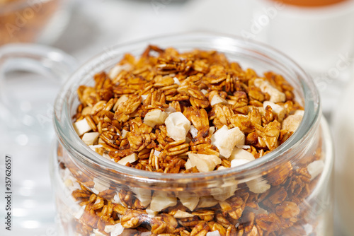 jar of sweet granola with coconut and nuts © cook_inspire