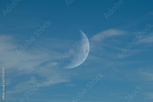 Clear Blue Sky with Whispy Faint Clouds and Faint Half Moon