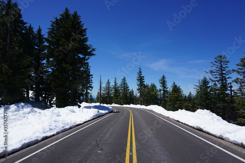 Empty road with snow in Crater Lake National Park - Oregon, United States