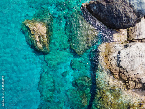 The beautiful rock formations and emerald sea of the Greek island Andros, Cylcades, during summer time