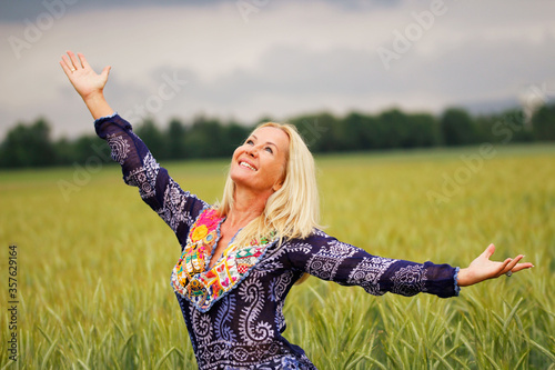 Beautiful woman feeling happy and free on a wheat field