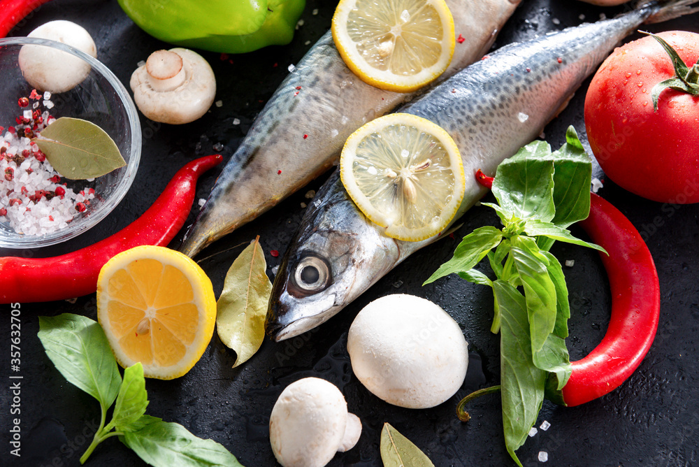 raw mackerel fish with lemon slices, Basil, tomato, chili pepper, mushrooms, salt and spices on a black background, raw mackerel fish with lemon slices, Basil, tomato, chili pepper, mushrooms, salt and spices on a black background,