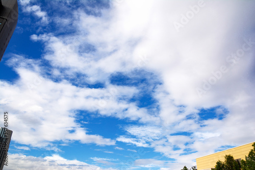 大阪の都会の高層ビルの合間に広がる、青い空、白い雲。 The buildings in the city & blue sky & white clouds at Osaka. © Sanae