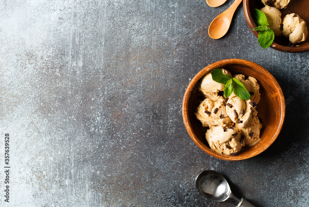 Fototapeta premium Coffee or chocolate ice cream scoop in wooden plate with mint leaf on dark background
