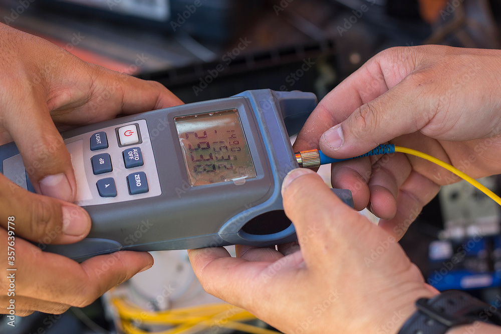 technicians are measuring light signals using power meter