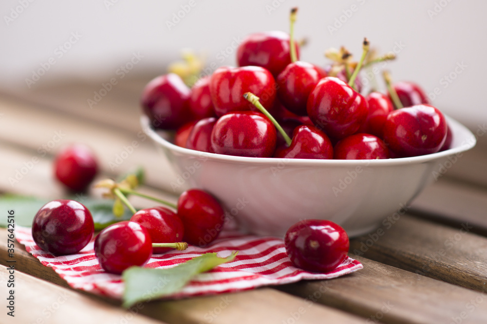 fresh cherries fruits in a white bowl on wooden table fresh cherries fruits in a white bowl on wooden table