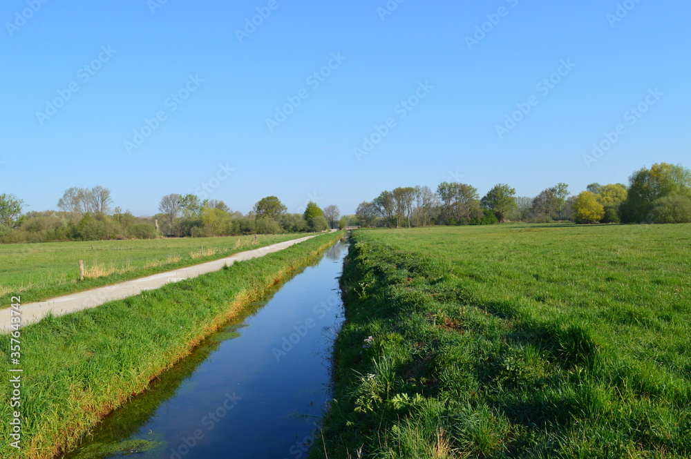Naklejka premium Traditionelle Niederrhein-Landschaft bei Grefrath-Oedt mit Feldern, Wanderweg und Entwässerungskanal