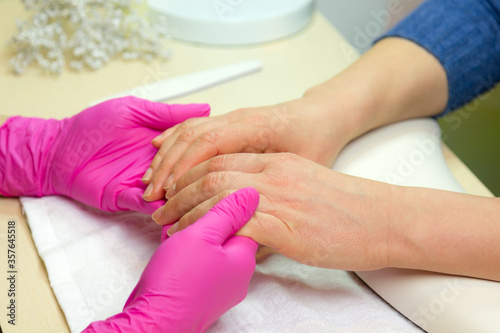 Closeup shot of a woman in a nail salon. Woman getting nail manicure..