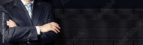 Crossed arms against crude oil barrel on black background. Crude oil and petroleum industry concept