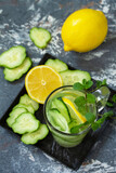 Fresh Cold and refreshing detox water with lemon and cucumber on a stone table.