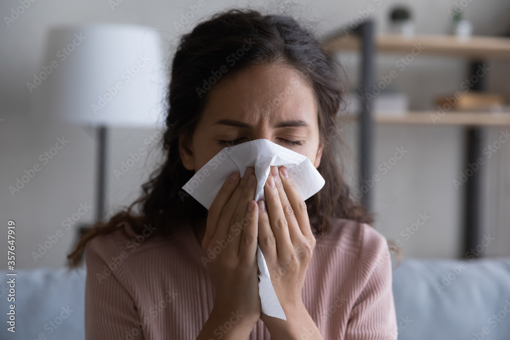 Close up sick woman blowing running nose, sneezing, holding white paper tissue handkerchief, unhealthy young female feeling unwell, symptom of chronic sinusitis, cold or flu, seasonal allergy Close up sick woman blowing running nose, sneezing, holding white paper tissue handkerchief, unhealthy young female feeling unwell, symptom of chronic sinusitis, cold or flu, seasonal allergy