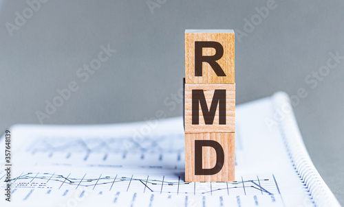 Wooden block with words RMD - acronim RMD - Required Minimum Distributions. Concept image of Accounting Business Acronym RMD Required Minimum Distributions. photo