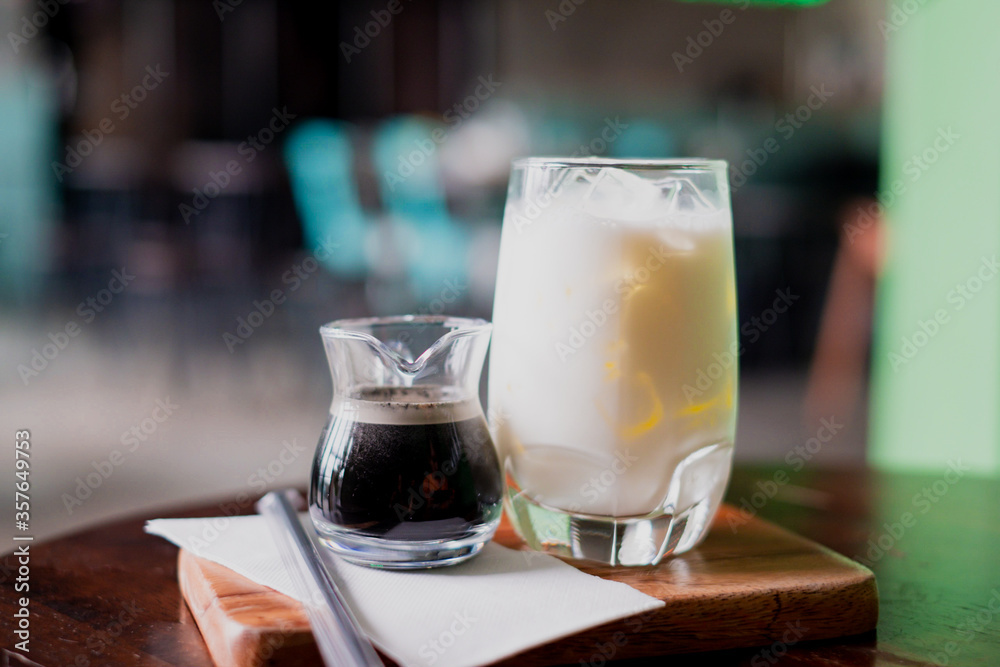 Coffee and milk in a glass, add ice, prepare to pour together to mix. Coffee and milk in a glass, add ice, prepare to pour together to mix.