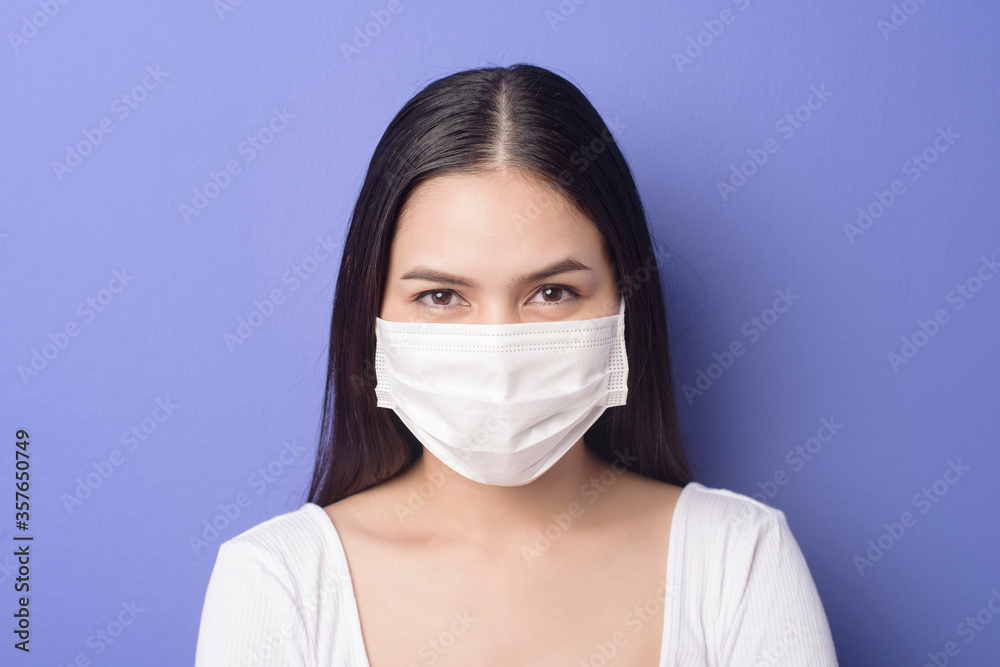 portrait of young woman is wearing face mask on purple background portrait of young woman is wearing face mask on purple background