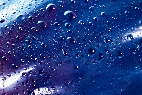 blue water drops on a glass bottle close-up macro. classic blue color