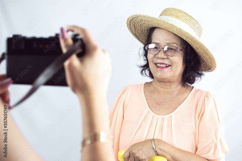 Old woman preparing to travel and taking photo on white background