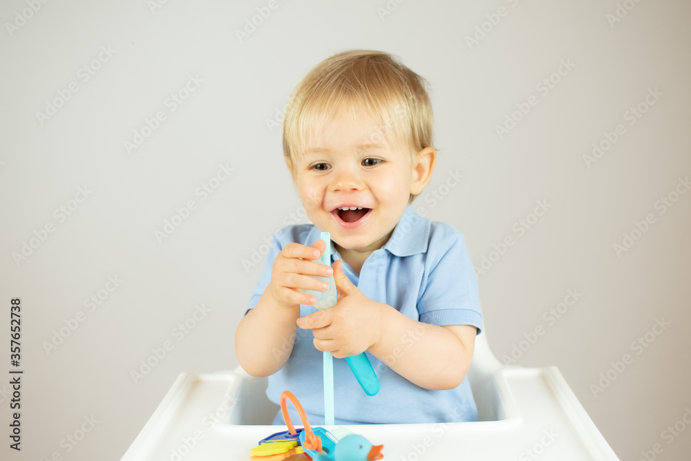 Blond baby with blue polo shirt sitting and gesturing Blond baby with blue polo shirt sitting and gesturing