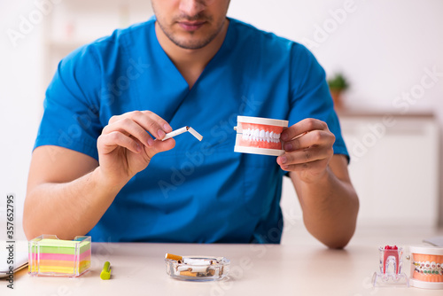 Young male dentist working in the clinic photo