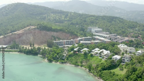 Wallpaper Mural Aerial panning shot of houses amidst green plants and trees by sea, drone flying over coastline against mountains - Ko Samui, Thailand Torontodigital.ca