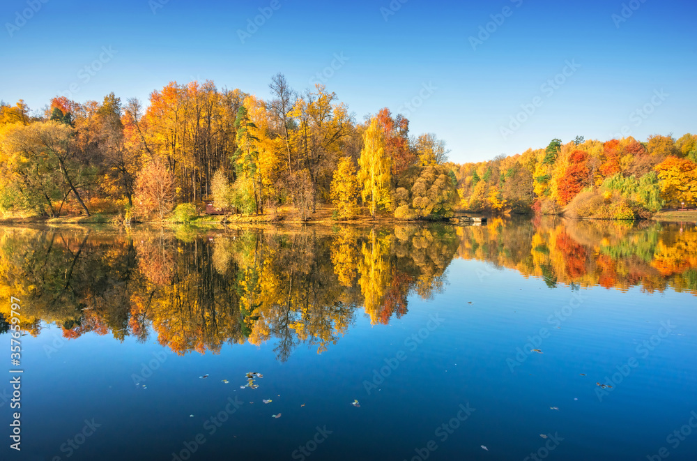 Colorful autumn trees in Tsaritsyno park in Moscow with mirror reflection