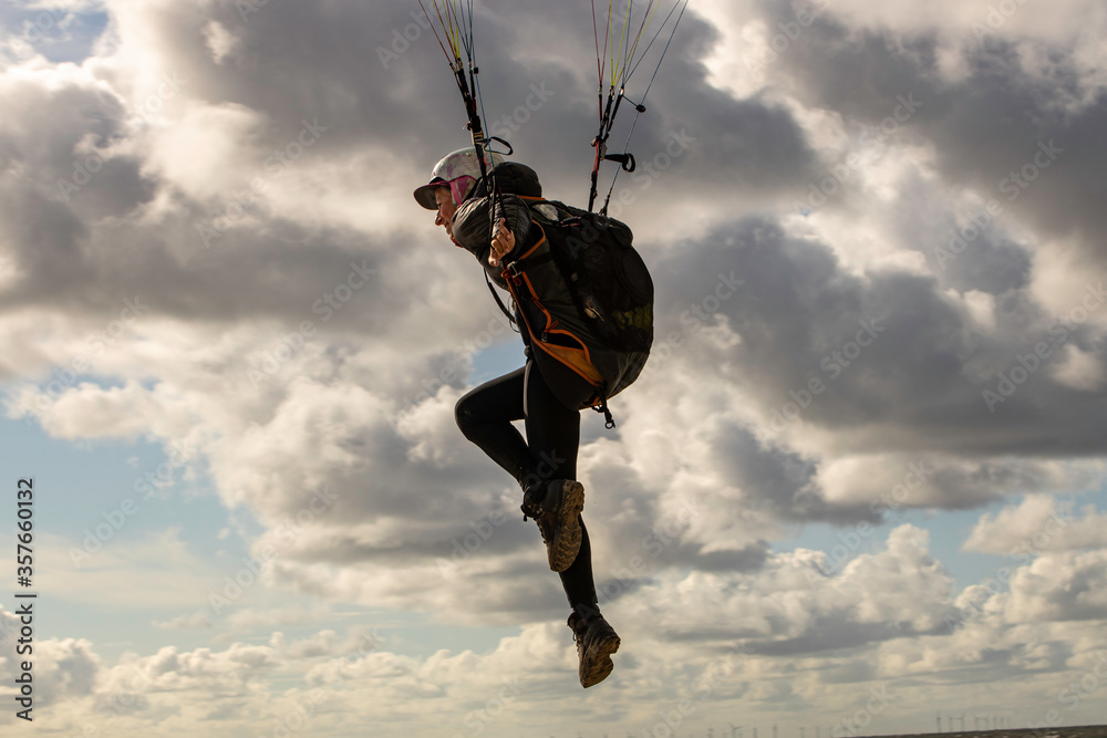 woman flying the paraglider alone in the sky woman flying the paraglider alone in the sky