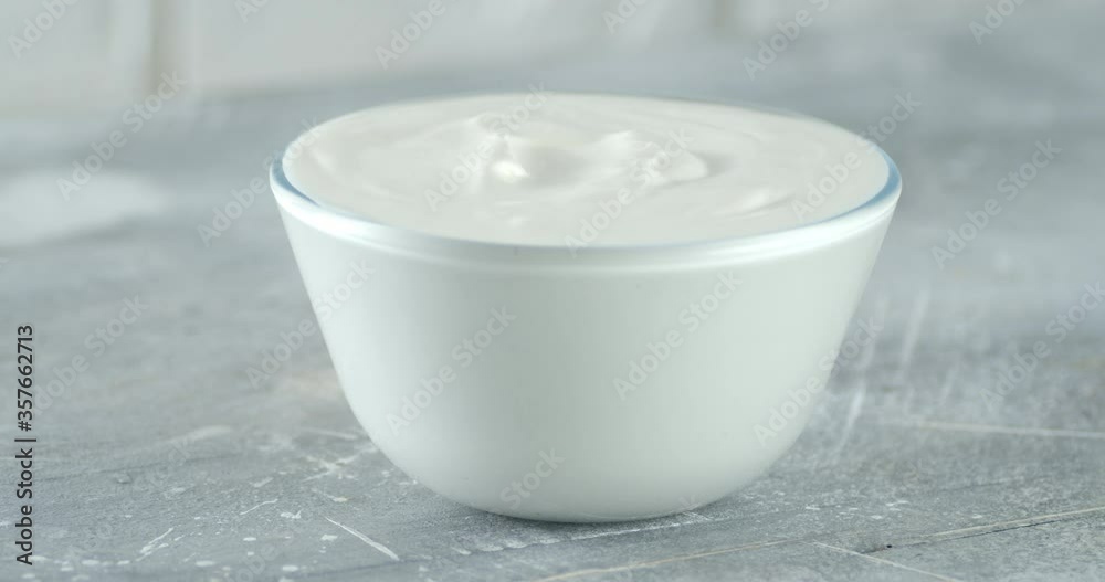 Sour cream in a glass bowl on the table slowly rotates. Sour cream in a glass bowl on the table slowly rotates.