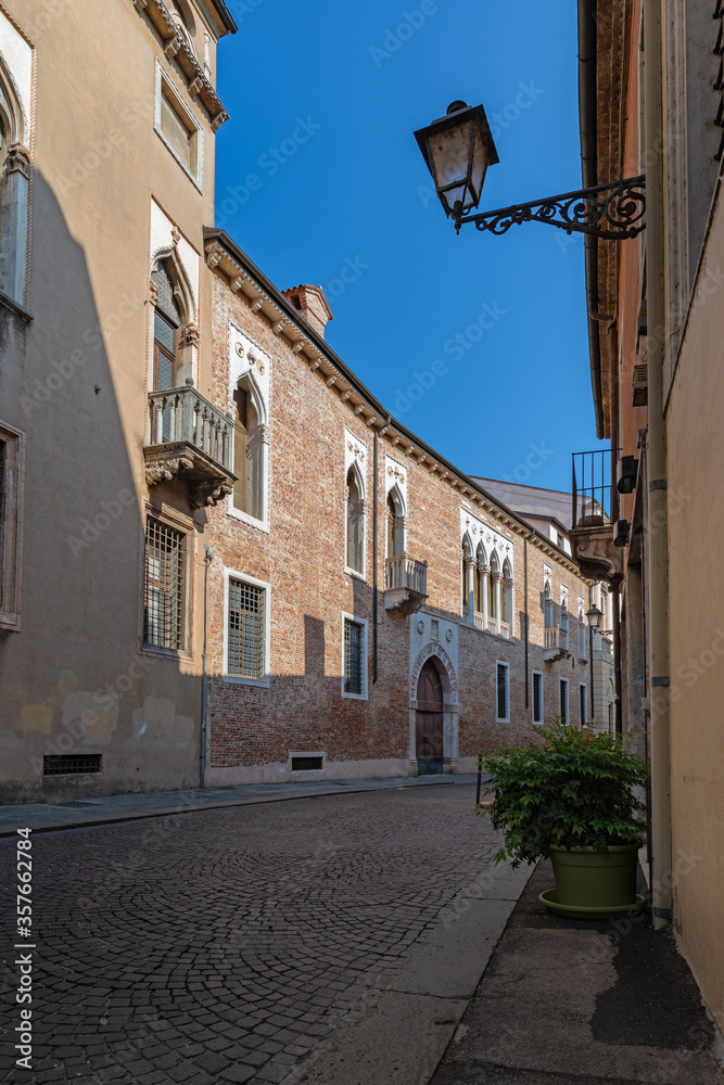 Fototapeta premium A stretch of Contra' Porti, one of the oldest street di Vicenza characterized by important ancient buildings, some are in Venetian Gothic style, with brick facade and marble windows. Italy.