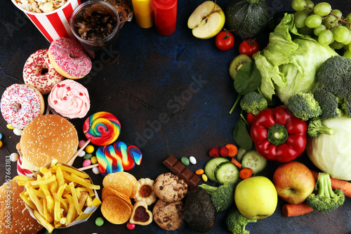 healthy or unhealthy food. Concept photo of healthy and unhealthy food. Fruits and vegetables vs donuts,sweets and burgers