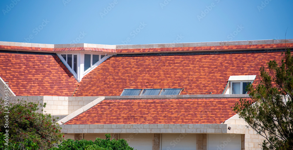 tiled roof with an attic against the blue sky
